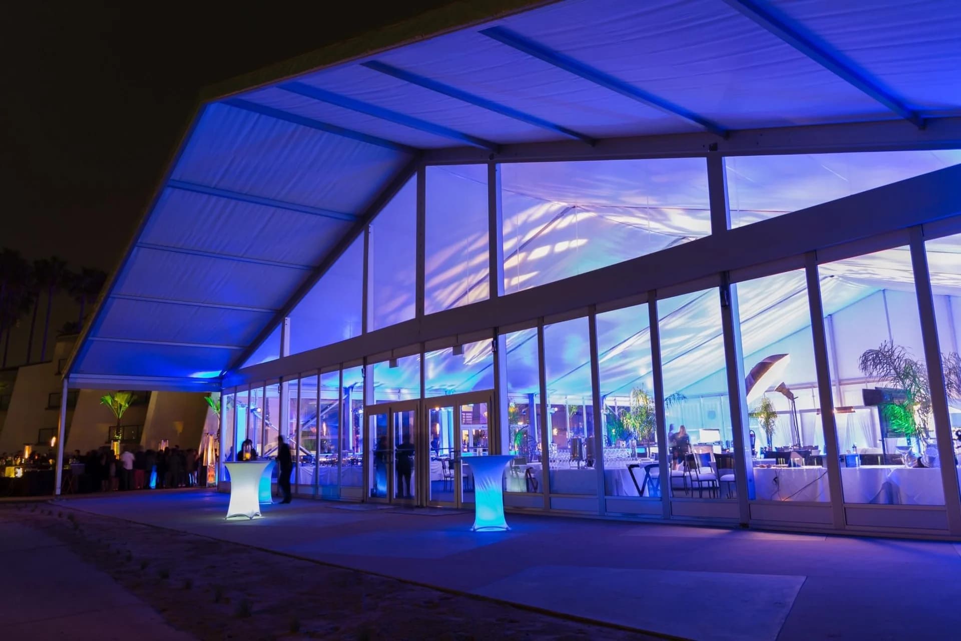 An illuminated glass-fronted event structure at night