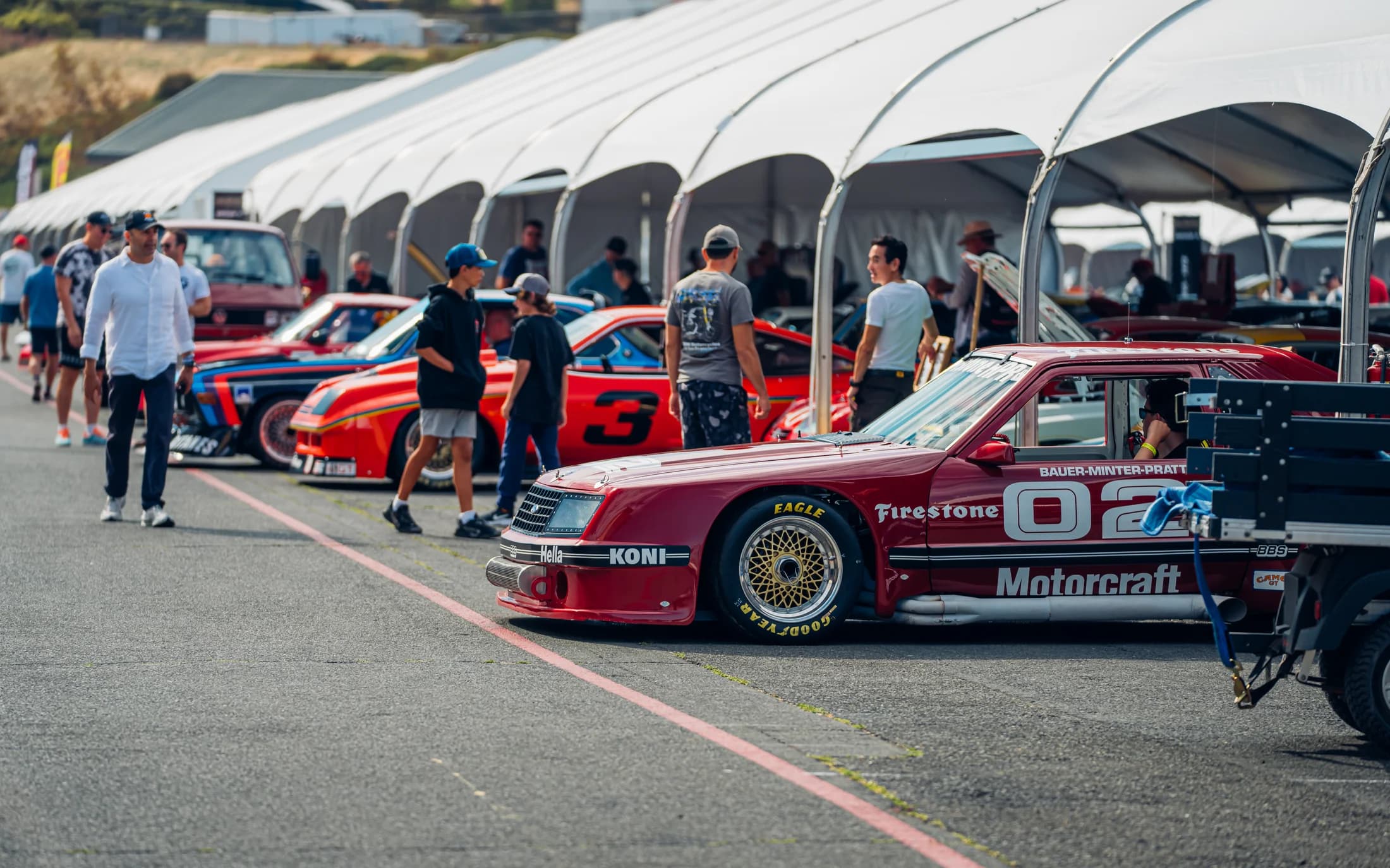 Curved-beam hospitality structures beside a motorsport event