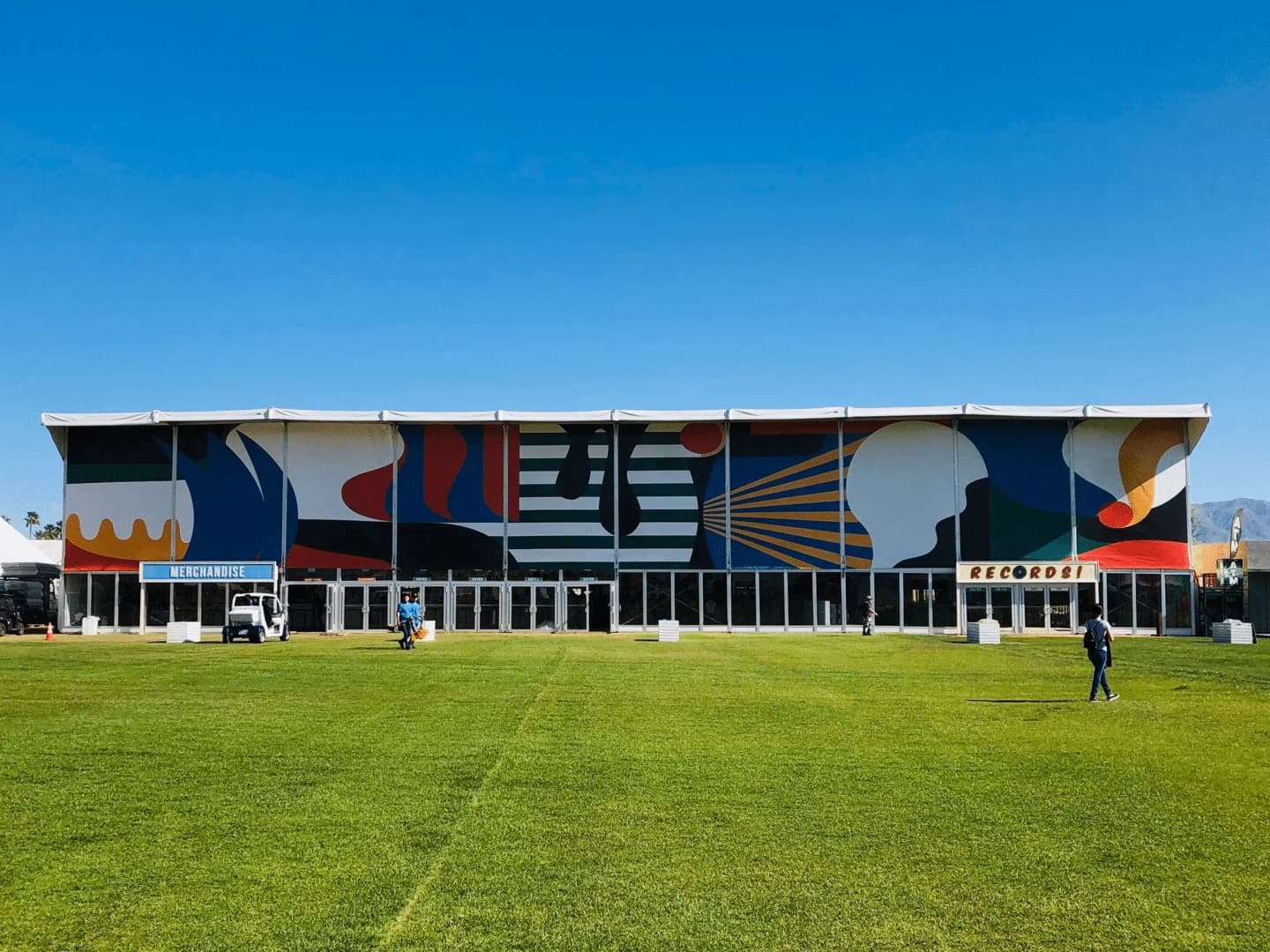 Choura temporary event building with a colorful facade and lawn