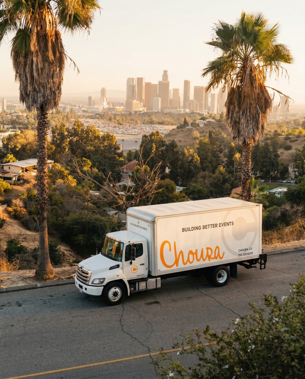 A Choura delivery truck with palm trees and the Los Angeles skyline behind it