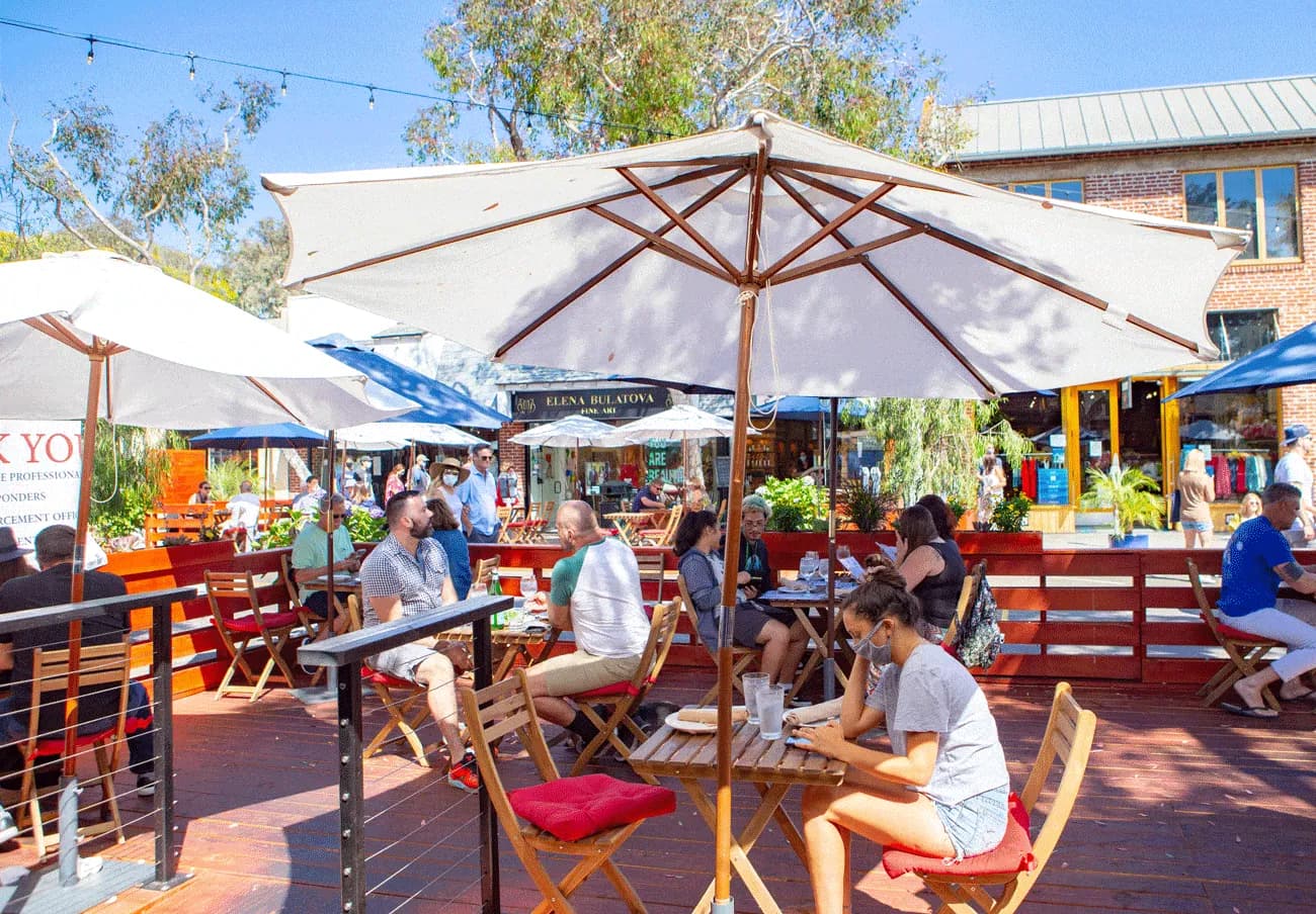 Woman looking at phone while seated at outside patio