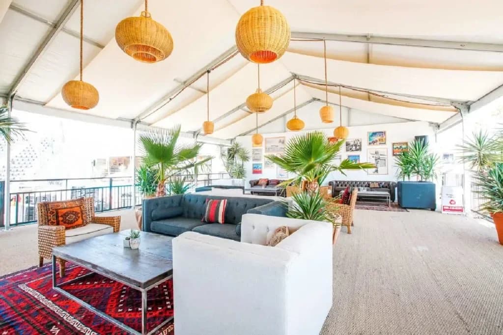 Choura-furnished event lounge beneath a tent with woven pendant lights